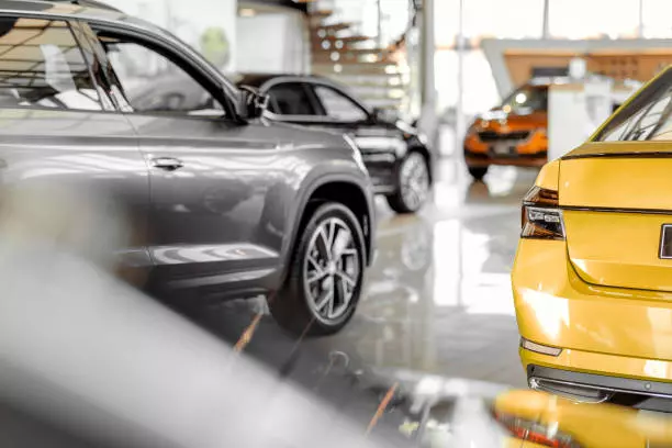 Car parked in luxury showroom. Car dealership office. New car parked in modern showroom. Car for sale and rent business concept. Automobile leasing and insurance concept.